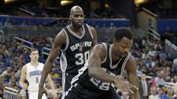 Pemain Spurs, Livio Jean-Charles #28 berebut bola dengan pemain Orlando Magic, Bismack Biyombo #11 pada laga NBA preseason basketball di Orlando. (AP/John Raoux)