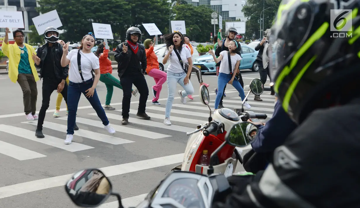 Sejumlah mahasiswa dan mahasiswi menari saat mengampanyekan keselamatan berlalu lintas di Jakarta, Rabu (20/3). Aksi ini mengajak pengendara untuk tertib berlalu lintas dengan #SelamatDijalan. (merdeka.com/Imam Buhori)