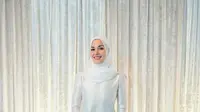 Tampil effortlessly elegan layaknya YM Dayang Anisha Rosnah, dengan mengenakan baju kurung bahan satin warna putih.[@muash.portfolio]