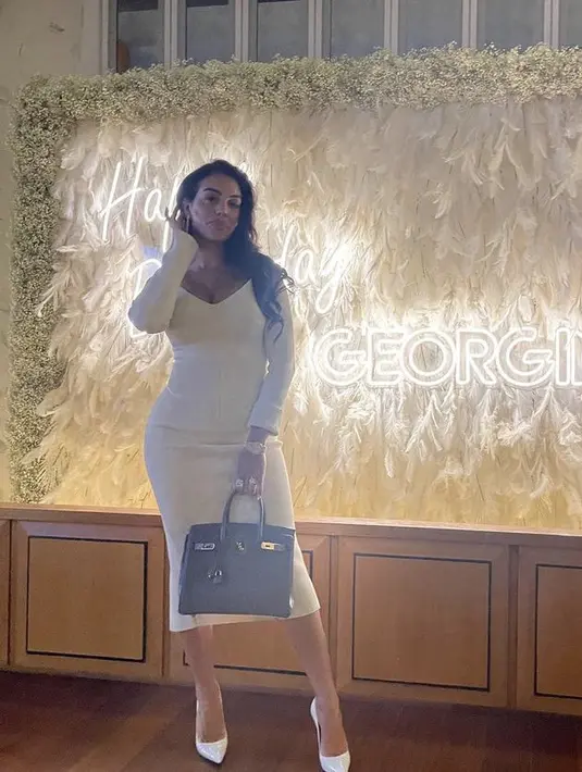 Saat ulang tahun, ia tampil dengan dress bodycon putih lengan panjang berdada rendah. Ia membawa tas Hermes dan mengenakan  stiletto heels putih. Credit:  (@georginagio)