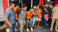 Eksekutor pembunuhan pengusaha tepung di Pekanbaru meringis kesakitan karena dua kakinya ditembak personel Polda Riau. (Liputan6.com/M Syukur)