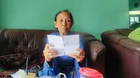 Nenek Giyem menunjukan bukti tanda terima sembako yang digunkan untuk penipuan pelaku (Hermawan Arifianto/Liputan6.com)