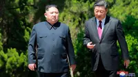 Pemimpin Korea Utara Kim Jong-un dan Presiden China Xi Jinping berbincang sambil berjalan di sela pertemuan di Dalian, Selasa (8/5). Ini adalah kunjungan kedua Kim ke China dalam dua bulan terakhir. (Korean Central News Agency/Korea News Service via AP)