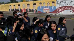 Sejumlah mahasiswa melintas di depan Mural bergambar empat mahasiswa Trisakti yang tewas pada 12 Mei 1998 lalu, Jakarta, Selasa (12/5/2015). Hingga kini pelaku dan dalang peristiwa 12 Mei 1998 belum terungkap. (Liputan6.com/Johan Tallo)