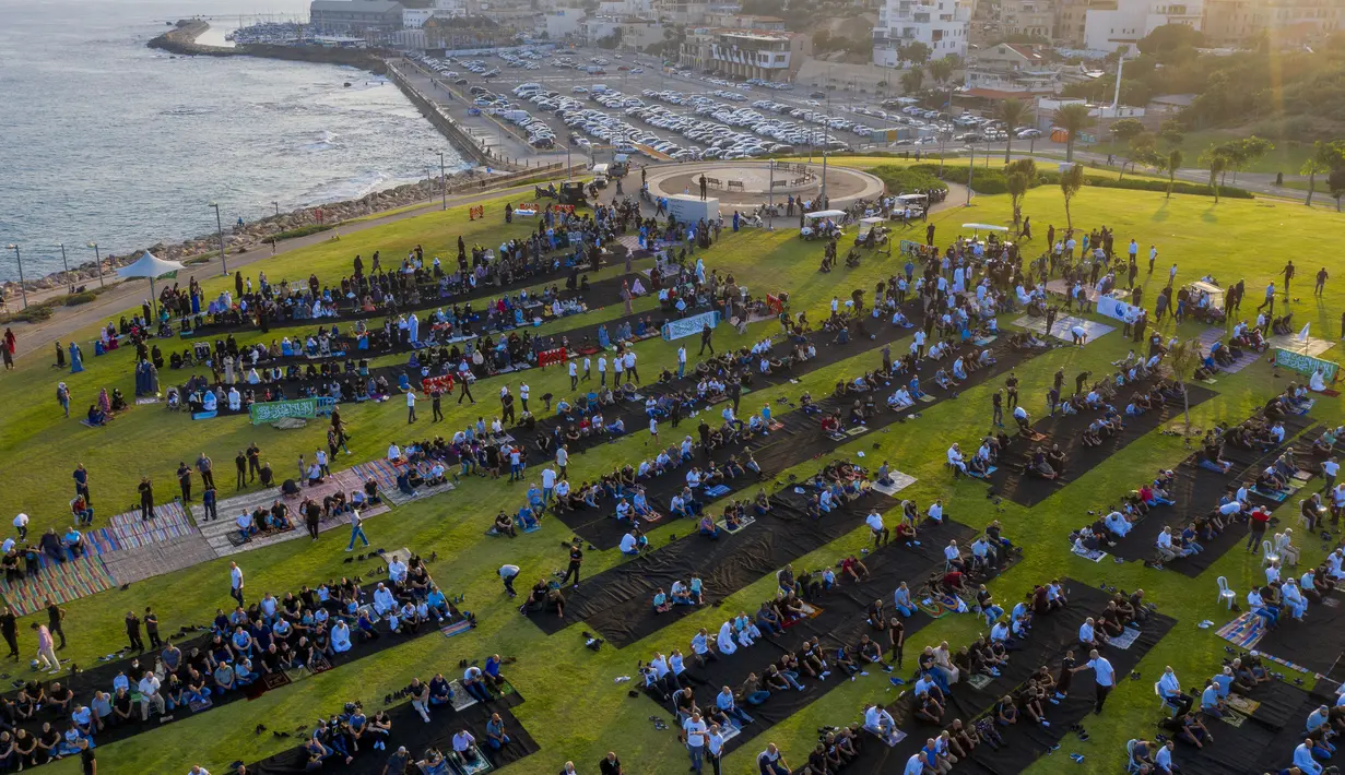 Umat muslim berkumpul melaksanakan salat Idul Adha di sebuah taman kota campuran Yahudi dan Arab, Jaffa, Israel, Jumat (31/7/2020). Ini adalah Idul Adha pertama sejak awal pandemi COVID-19. (AP Photo/Oded Balilty)