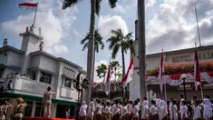 Para peserta memberi hormat saat reka ulang insiden Hotel Yamato atau Hotel Majapahit pada 19 September 1945, Surabaya, Minggu 22 September 2024. (JUNI KRISWANTO/AFP)