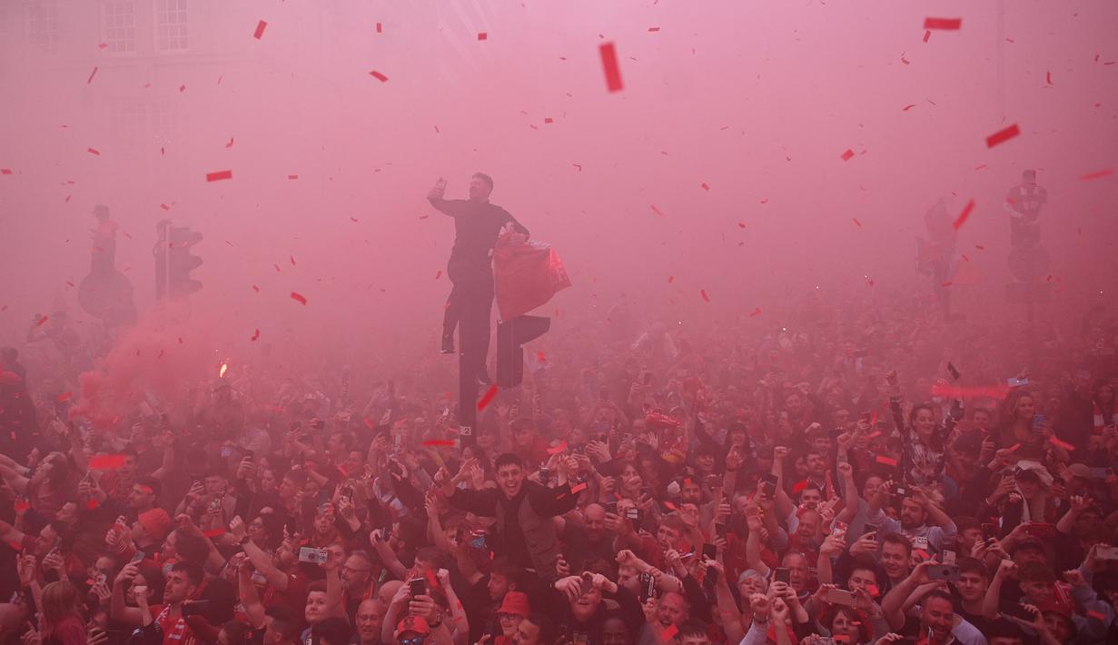 Ribuan fans Liverpool memadati jalan-jalan kota untuk menyambut tim kebanggaan mereka yang melakukan parade di atas bus terbuka pada Minggu (29/05/2022) waktu setempat. Musim ini, The Reds berhasil meraih dua trofi yaitu Piala FA dan Piala Liga Inggris. (AFP/Oli Scarff)