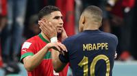 Bek Maroko Achraf Hakimi dihibur oleh penyerang Prancis Kylian Mbappe usai pertandingan semifinal Piala Dunia 2022 di Stadion Al-Bayt di Al Khor, Doha, Kamis (15/12/2022). Maroko gagal melaju ke final Piala Dunia 2022 Qatar setelah kalah dari Prancis dengan skor 2-0. (AFP/Karim Jaafar)