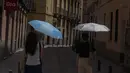 <p>Dua perempuan berjalan dengan payung di pusat kota Madrid, Spanyol, Minggu (12/6/2022). Layanan cuaca Spanyol mengatakan massa udara panas dari Afrika utara memicu gelombang panas besar pertama di negara itu tahun ini dengan suhu diperkirakan naik hingga 43 derajat Celcius (109 derajat Fahrenheit) di area tertentu. (AP Photo/Paul White)</p>