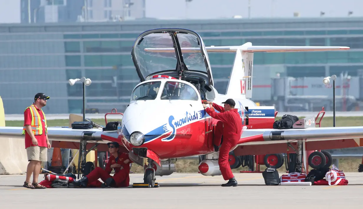 Kapten Regan Wickett (kanan)  dan pilot Patricia Brunelle (tengah) mempersiapkan pesawat jet Snowbird untuk mengikuti Canadian International Air Show di Bandara Pearson, Toronto (3/9/2015). Acara ini digelar selama tiga hari. (REUTERS/Louis Nastro)