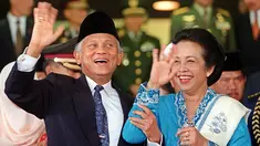 Presiden BJ Habibie didampingi istrinya Ainun Habibie melambaikan tangan kepada wartawan usai menghadiri upacara pelantikan anggota baru parlemen di luar Gedung Parlemen, Jakarta, 1 Oktober 1999. Habibie meninggal pada Rabu, 11 September 2019 pukul 18.05 WIB. (AFP Photo/STR)