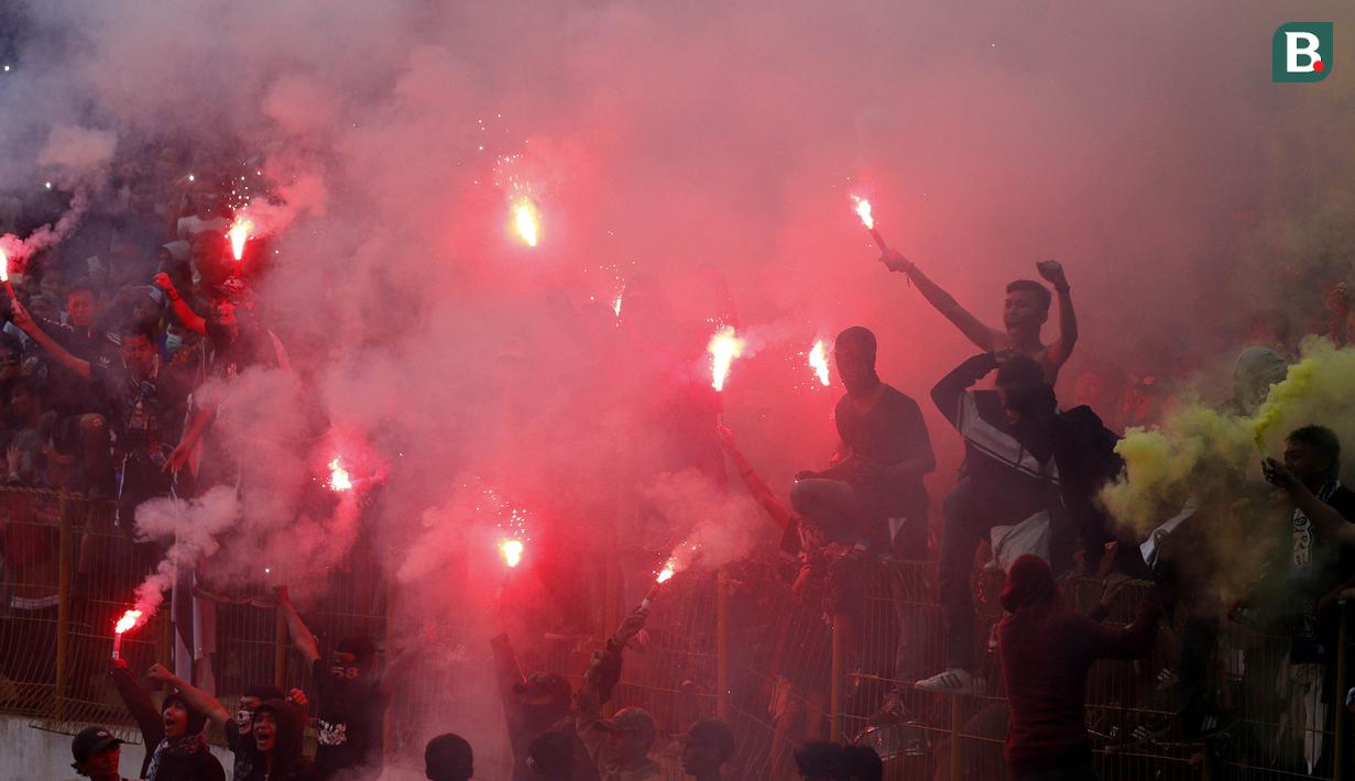 Suportermenyalakan flare saat menyaksikan pertandingan antara Perserang Serang melawan Persib Bandung pada laga uji coba di Stadion Maulana Yusuf, Serang, Kamis (1/3/2018). Persib menang 6-0 atas Perserang. (Bola.com/M Iqbal Ichsan)