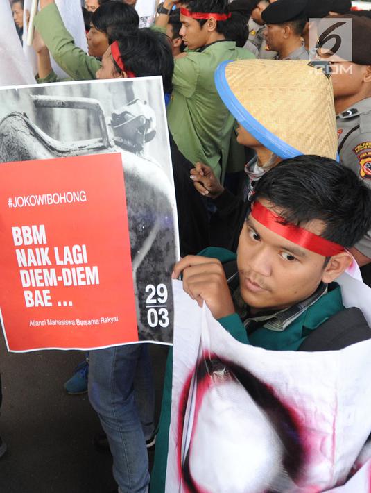 Seorang mahasiswa yang tergabung dalam Kesatuan Aksi Mahasiswa Muslim Indonesia (KAMMI) Bogor menunjukkan poster saat melakukan aksi menolak harga kenaikan BBM di Jalan Ir. H.Djuanda, Bogor (29/03). (Merdeka.com/Arie Basuki)