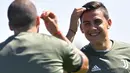 Pemain Juventus, Paulo Dybala (kanan) santai mengikuti sesi latihan jelang melawan Barcelona di Vinovo, Turin, (11/9/2017. Juventus akan melawan Barcelona pada grup A Liga Champions. (AFP/Marco Bertorello)