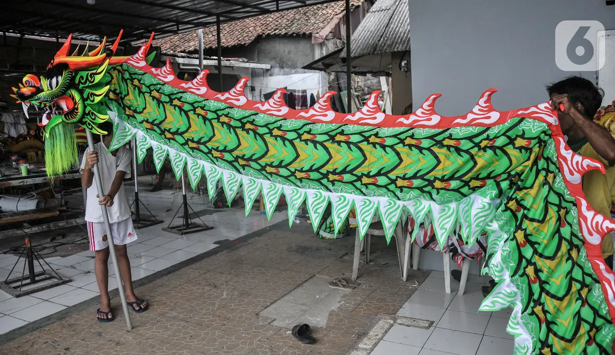 Pekerja saat menyelesaikan pembuatan Liong dan Barongsai di kawasan Babakan Pasar, Bogor, Jawa Barat, Senin (17/1/2022). Barongsai dibanderol dengan harga jual mulai Rp5 juta per buah sementara liong dihargai mulai Rp8 juta per buah. (merdeka.com/Iqbal S Nugroho)