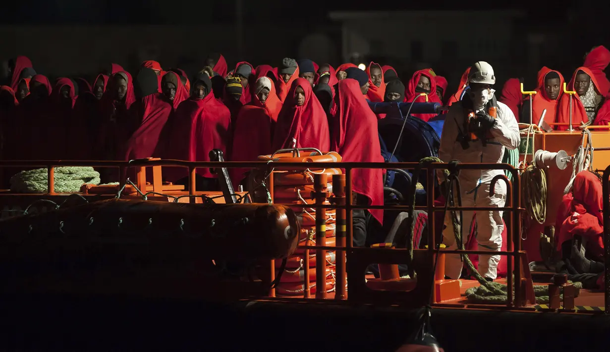 Sekelompok imigran berdiri di kapal penyelamat ketika tiba di pelabuhan Malaga, Spanyol, Selasa, (11/2/2020). Otoritas maritim Spanyol pada Senin (11/2) menyelamatkan 119 imigran dari laut dan sedang mencari 67 lainnya yang mencoba mencapai pantai Eropa. (AP Photo/Jesus Merida)