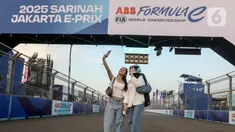 Warga berswafoto di lintasan Formula E World Championship usai menyaksikan sesi Free Practice 1 (FP1) di Jakarta International E-Prix Circuit (JIEC) di Ancol, Jumat (20/6/2025). (Liputan6.com/Herman Zakharia)