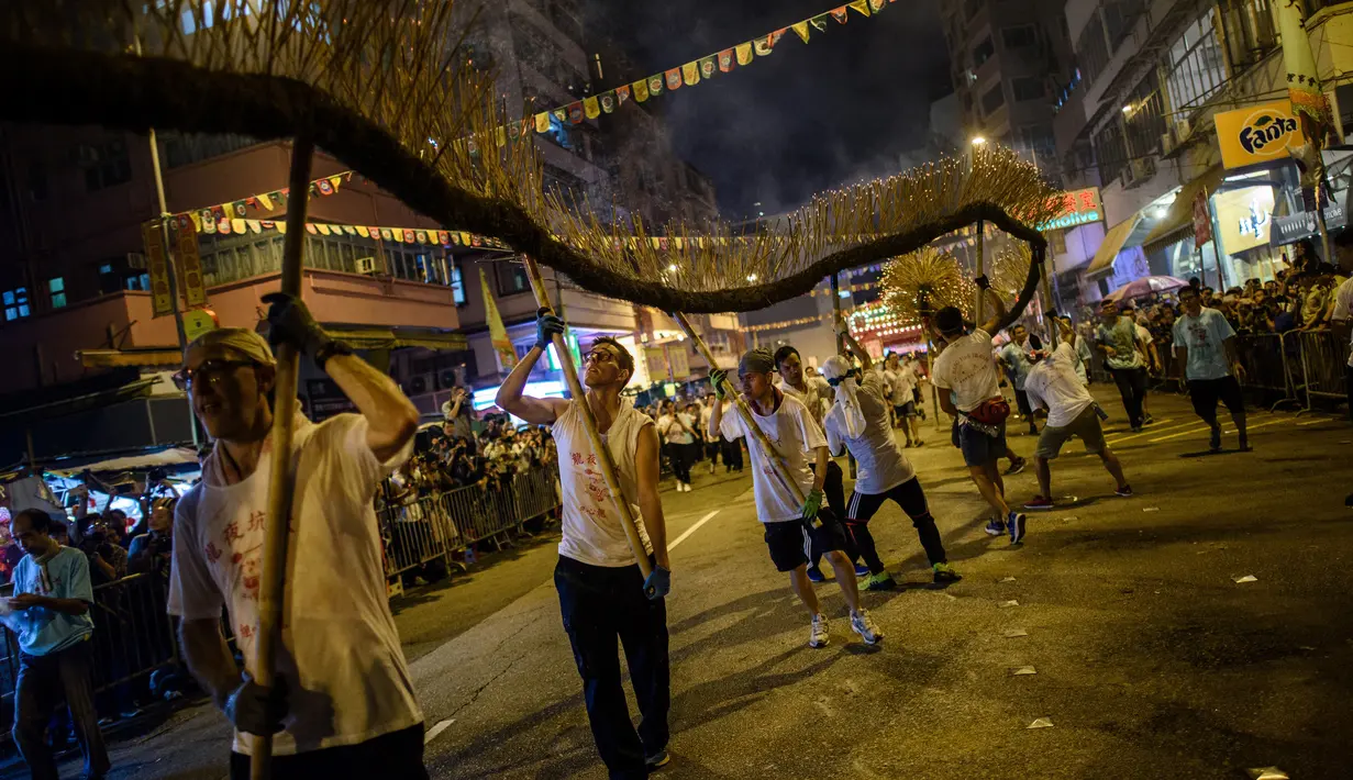 Peserta memainkan kesenian tradisional tari Naga Api Tai Hang di Hong Kong (3/10). Pertunjukan Naga Api ini melibatkan sekitar 300 orang. (AFP Photo/Anthony Wallace)