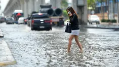 Seorang wanita menyeberangi sebuah jalan yang terendam banjir pascahujan lebat di Bangkok, Thailand (31/8/2020). (Xinhua/Rachen Sageamsak)