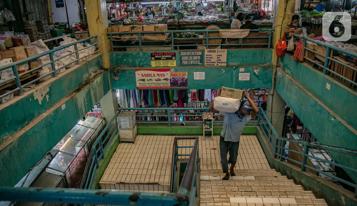 Seorang pria memanggul barang di Pasar Pondok Labu, Jakarta, Rabu (10/2/2021). Satu pedagang dinyatakan positif Covid-19, meski begitu pengelola Pasar Pondok Labu tetap melanjutkan operasional pasar sambil melakukan penyemprotan cairan disinfektan selama tiga hari. (Liputan6.com/Faizal Fanani)