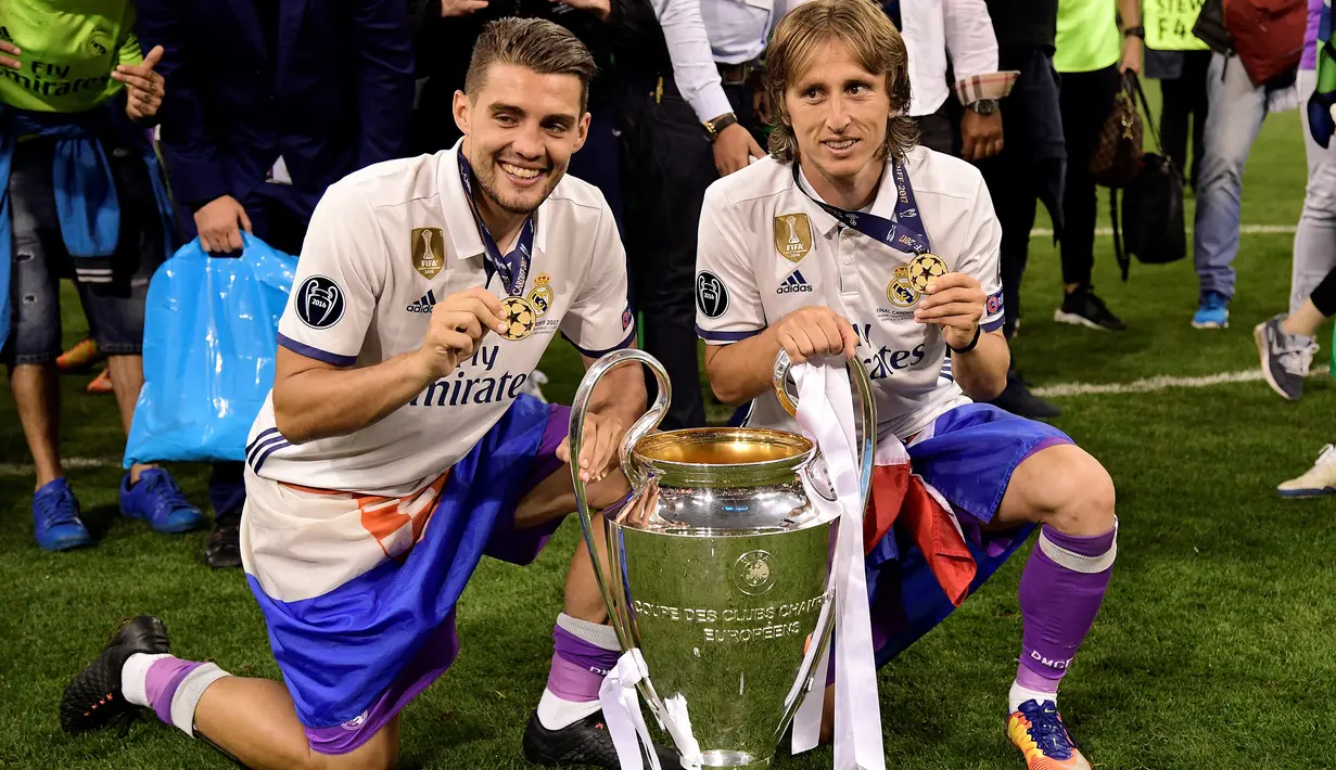 Selebrasi dua pemain Real Madrid, Luka Modric (kanan) dan Mateo Kovacic dengan medali dan trofi juara Liga Champions 2016/2017 setelah mengalahkan Juventus pada laga final di Principality Stadium, Cardiff, Wales (3/6/2017). Pada musim 2017/2018 Luka Modric dan Mateo Kovacic menjadi dua pemain Kroasia yang membawa Real Madrid menjuarai Liga Champions dengan mengalahkan Liverpool 3-1 di partai final. Keberhasilan keduanya menjadi hattrick setelah pada musim 2015/2016 dan 2016/2017 juga membawa Real Madrid juara. (AFP/Javier Soriano)