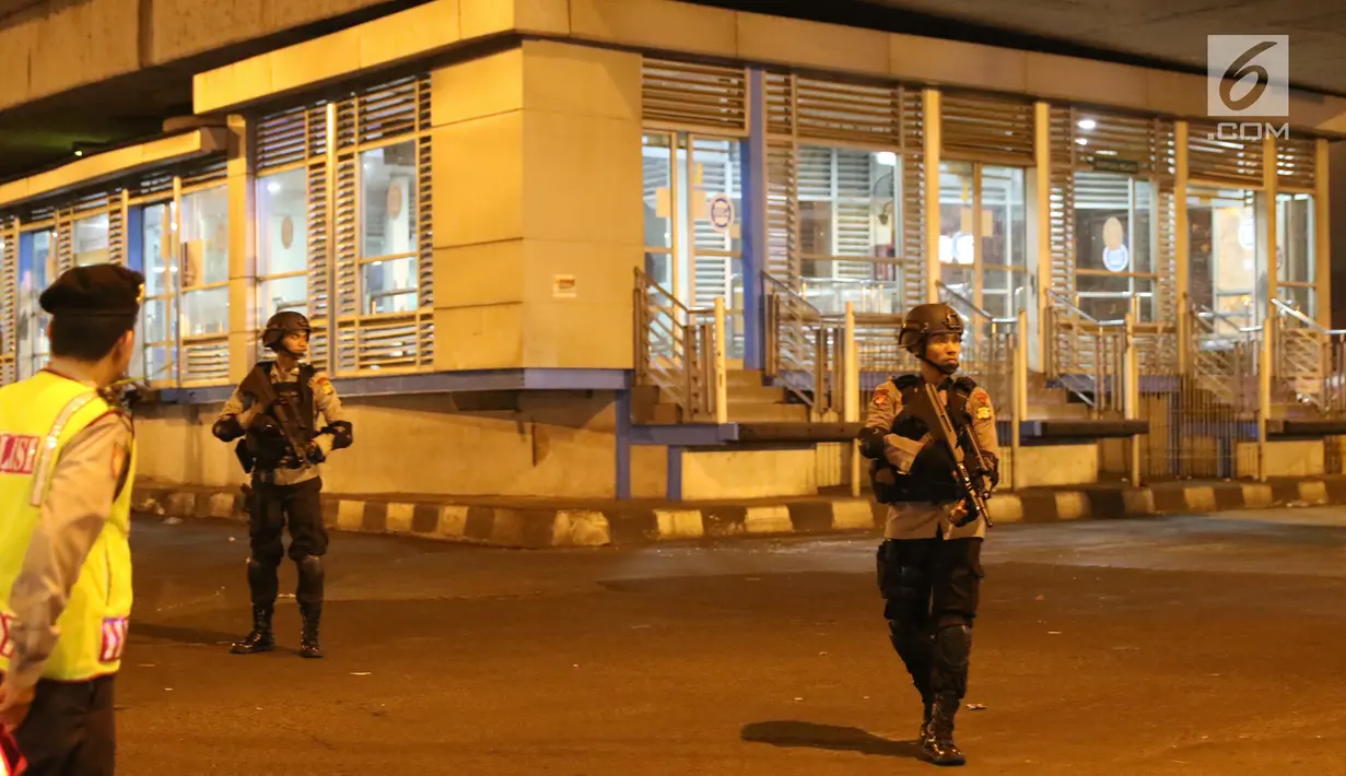 Polisi berjaga di sekitar Terminal Kampung Melayu, Jakarta, Rabu (24/5). Tim gegana tengah menyisir lokasi ledakan. (Liputan6.com/Angga Yuniar)