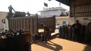 Kembalinya pasokan bahan bakar gas ke Gaza—meski dalam jumlah terbatas—memberikan secercah harapan bagi keluarga yang selama ini hidup dalam kegelapan dan kelaparan. Tampak dalam foto, pekerja Palestina memuat tabung gas, untuk pertama kalinya dalam setahun, di stasiun pengisian resmi di kamp pengungsi Nuseirat, di bagian tengah Jalur Gaza, pada 10 November 2025. (Eyad Baba/AFP)