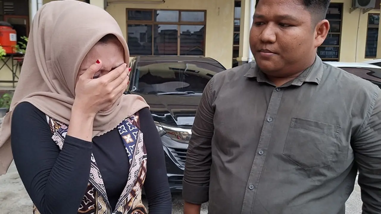 Korban kekerasan dalam rumah tangga yang dilakukan oknum polisi di Polresta Pekanbaru mengusap matanya mengingat penganiayaan yang pernah dialaminya.