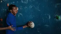 Seorang remaja tuna netra bernama Dominic Hezron mencoba menyentuh papan panjat dinding saat acara pelatihan di Nairobi, Kenya (15/3). Latihan panjat dinding tuna netra ini diselenggarakan oleh NPO Monkey Magic. (AFP/Yasuyoshi Chiba)