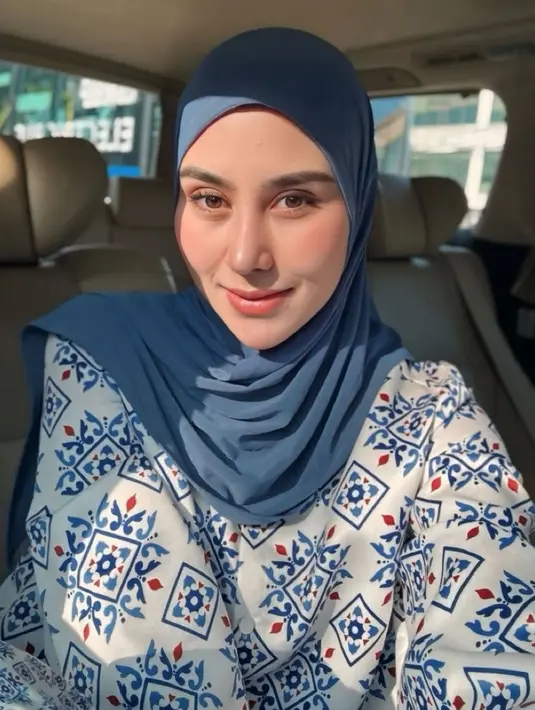 Syahnaz Sadiqah hadir serba biru memadukan kerudung biru polos dengan atasan lengan panjang warna dasar putih dengan corak warna biru. [@syahnazs]