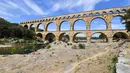 Pemandangan Pont du Gard atau Jembatan Gard di Vers-Pont-du-Gard, Prancis, Rabu (21/8/2019). Pont du Gard adalah jembatan saluran air Romawi yang merupakan bagian dari daftar situs warisan dunia UNESCO. (Pascal GUYOT/AFP)