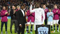 Gelandang Manchester City, Yaya Toure, mendapatkan penghargaan saat perpisahan di Stadion Etihad, Rabu (9/5/2018). Laga tersebut menjadi ajang perpisahan sang pemain bersama The Citizens. (AFP/Oli Scarff)