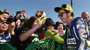 Valentino Rossi dikelilingi penggemarnya di paddock sebelum latihan bebas GP Jepang di Sirkuit Motegi, Jepang, (9/10/2015). (AFP Photo/Kazuhiro Nogi)