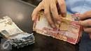 Petugas mengecek uang rusak yang ditukarkan di Bank Indonesia, Jakarta, Senin (6/6). BI meminta masyarakat menukarkan uang yang sudah tidak layak edar dengan uang baru agar uang yang beredar tetap berkualitas tinggi. (Liputan6.com/Immanue Antonius)
