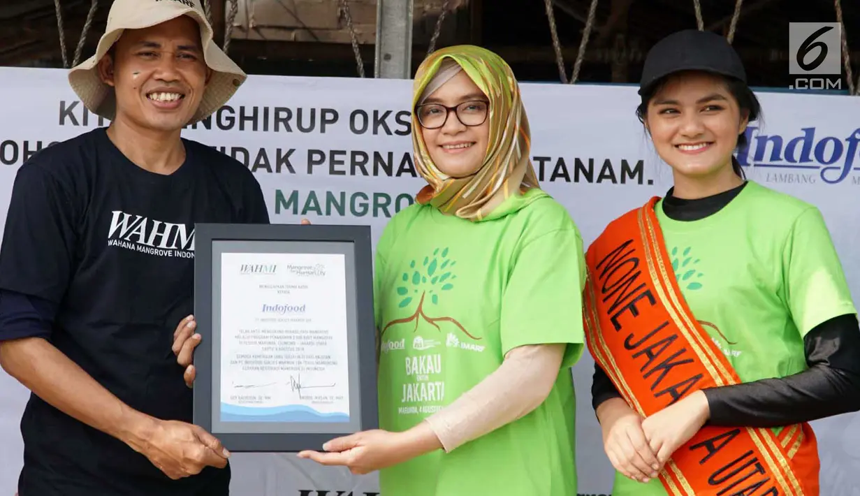 Head of Corporate PR PT Indofood Sukses Makmur Nurulita Novi Arlaida (kedua kanan) dan one Jakarta Utara 2018 Puja Oktaviana (kanan) memberikan cenderamata kepada Nurul Ikhsan di Pesisir Merunda, Jakarta Utara, Sabtu (4/8). (Liputan6.com/HO/Eko)
