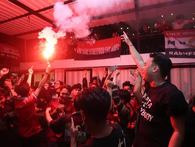 Fans Manchester United menyalakan Flaire saat&nbsp;acara Roaring night Manchester United vs Liverpool di Pitch 98, Kemang, Jakarta Selatan, Minggu (7/4/2024). (Bola.com/M Iqbal Ichsan)