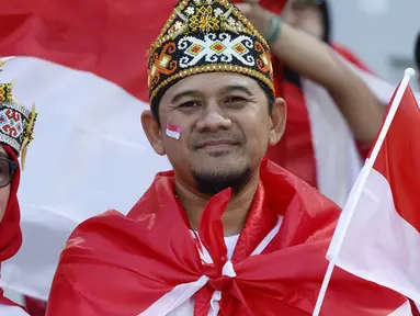 Suporter Timnas Indonesia berpose sebelum dimulainya pertandingan sepak bola Grup D Piala Asia 2023 antara Vietnam dan Indonesia di Stadion Abdullah bin Khalifa, Doha, Qatar, Jumat (19/1/2024). (KARIM JAAFAR/AFP)