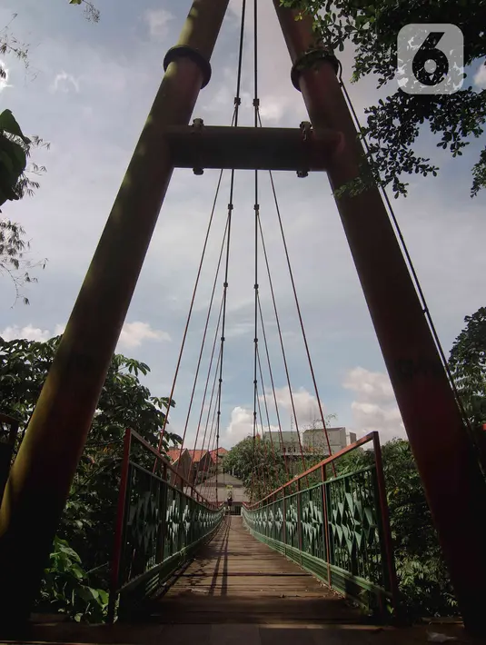 Kondisi jembatan yang berlubang di Jembatan Wiratman, Srengseng Sawah, Jakarta, Sabtu (12/3/2022). Jembatan tersebut mengalami kerusakan pada papan pijak yang mulai berlubang serta besi yang berkarat dan dapat membahayakan warga yang melintas. (Liputan6.com/Herman Zakharia)