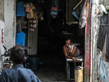 Seorang warga beristirahat di permukiman padat penduduk Kampung Muka RW 04, Ancol, Pademangan, Jakarta, Selasa (4/1/2022). Gubernur DKI Jakarta Anies Baswedan memastikan 1.000 kepala keluarga (KK) di kampung tersebut mendapatkan Izin Mendirikan Bangunan (IMB) kolektif. (Liputan6.com/Faizal Fanani)