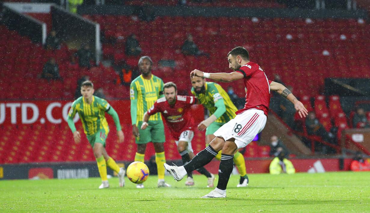 Gelandang Manchester United, Bruno Fernandes, melepaskan tendangan penalti ke gawang West Bromwich Albion pada laga Liga Inggris di Stadion Old Trafford, Minggu (22/11/2020). MU menang dengan skor 1-0. (Alex Livesey/Pool via AP)