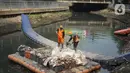 Petugas membersihkan sampah di sepanjang Kali Taman Anggrek, Jakarta, Rabu (8/7/2020). Banyaknya limbah menyebabkan Kali Taman Anggrek menjadi berwarna hitam dan berbau tidak sedap meskipun dibersihkan setiap hari. (Liputan6.com/Immanuel Antonius)