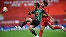 Bek Aston Villa Neil Taylor (tengah) berebut bola dengan gelandang Liverpool Mohamed Salah (kanan) dalam lanjutan Premier League 2019-2020, Minggu (5/7/2020). Liverpool berhasil meraih kemenangan atas Aston Villa dengan skor 2-0. (Paul ELLIS / POOL / AFP)