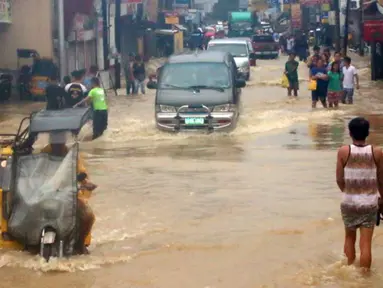 Banjir terjadi akibat hujan deras yang dibawa oleh Topan Goni di Kota Condon, Ilocos sur, Filipina, Senin (24/8/2015). Topan yang membawa angin berkecepatan 140 km/jam hingga 195 km/jam tersebut diperkirakan akan menerjang Okinawa, Jepang. (AFP Photo)