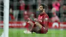 Winger Liverpool, Mohamed Salah duduk di depan gawang setelah mencetak gol ke gawang Huddersfield Town dalam laga lanjutan Premier League 2018-19 pekan ke-36 di Anfield, Jumat (26/4). Bermain di kandang sendiri, Liverpool menang dengan skor telak 5-0.  (AP Photo/Jon Super)