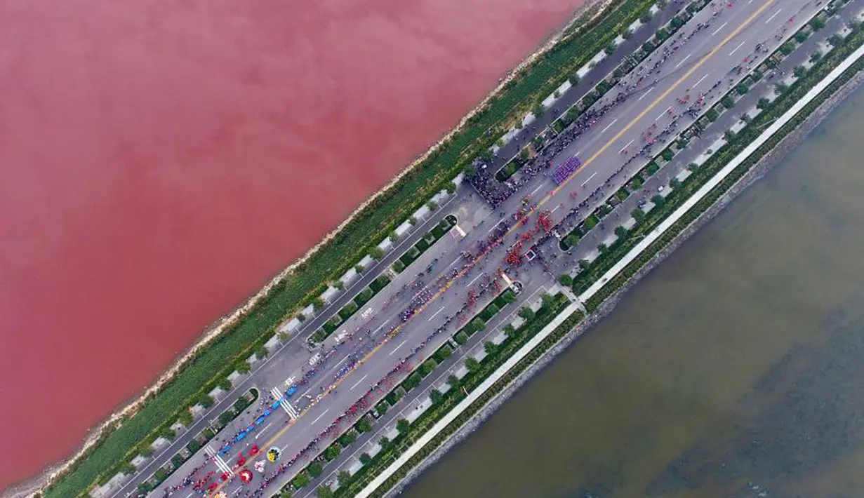 Air danau yang berubah menjadi merah menjadi tontonan warga, Yunchen, Shanxi, Tiongkok, Minggu (25/9). Warga berbondong-bondong melihat fenomena yang langka tersebut. (chinadaily.com.cn)