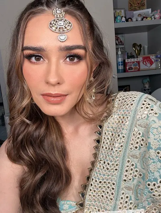 Yasmine Wildblood mengenakan aksesori kepala khas perempuan India. Dengan sari berbordir warna biru keemasan. [@yaswildblood]