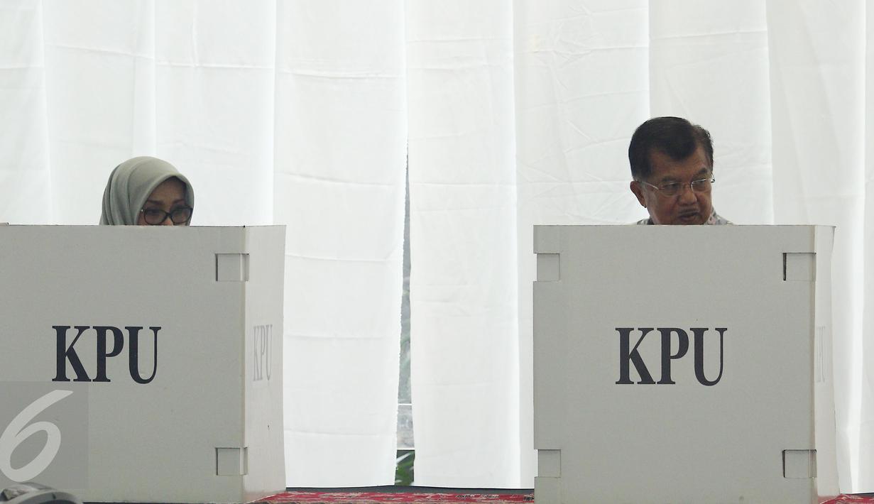 Wakil Presiden Jusuf Kalla (JK) bersama istri, Mufidah Kalla, melakukan pencoblosan di TPS 03 Kelurahan Pulo, Jakarta Selatan, Rabu (19/4). Di TPS bernuansa Betawi itu, JK memberikan suaranya pada Pilkada DKI putaran kedua. (Liputan6.com/Herman Zakharia)