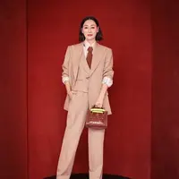 Hui Yinghong tampil dengan mengenakan setelan jas tiga potong, kemeja crepe sutra merah muda, dasi cokelat, sepatu hak tinggi kulit hitam, dan tas Gucci Diana. Sumber: Document/Gucci.