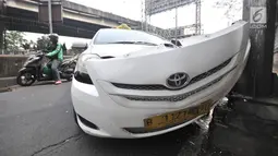 Kondisi taksi yang menabrak tiang di Jalan Ahmad Yani, Jakarta, Rabu (1/8). Mobil taksi berpelat nomor B 1121 BTD tersebut mengalami kerusakan parah pada bagian depan. (Merdeka.com/Iqbal Nugroho)