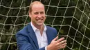 Pangeran William bereaksi melihat bola yang hampir masuk ke gawangnya saat bermain bersama anak-anak program pendidikan sepak bola wanita Inggris, Wildcats Girls, di Kensington Palace, London, Kamis (13/7). (Dominic Lipinski / POOL / AFP)